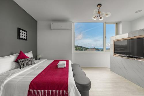 a bedroom with a large bed and a large tv at Sunset Mu Style Inn in Xiaoliuqiu