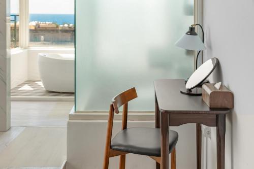 a desk with a lamp and a chair next to a window at Sunset Mu Style Inn in Xiaoliuqiu