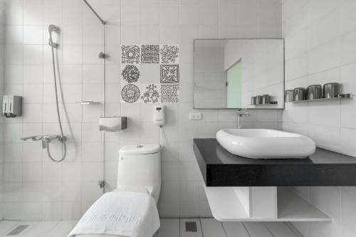 a bathroom with a toilet and a sink and a shower at Sunset Mu Style Inn in Xiaoliuqiu