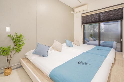 Un dormitorio con dos camas y una gran ventana. en 桜の川70-36池袋駅8分钟 1DK套房 max5人房 宽敞安静 ikeburuko, en Tokio