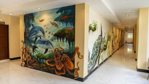 a hallway with a painting of an aquarium at Andi Beach House in Canggu