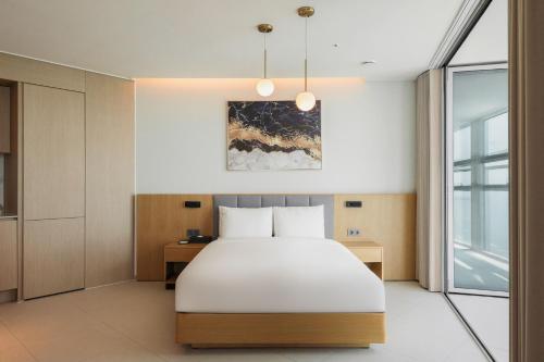 a bedroom with a white bed and a window at WAVEM HOTEL west in Siheung
