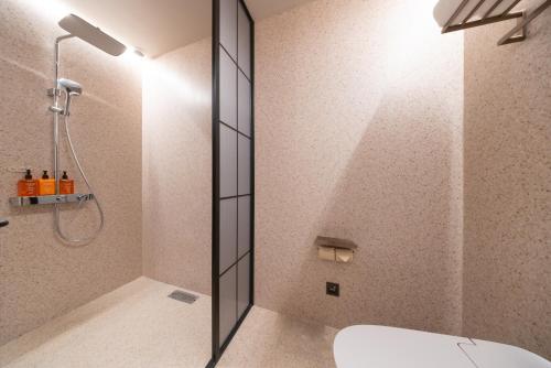 a bathroom with a shower and a toilet at Orange Hotel Beijing Shiliuzhuang Subway Station in Beijing