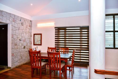 a dining room with a table and chairs at Valley View in Kodaikānāl