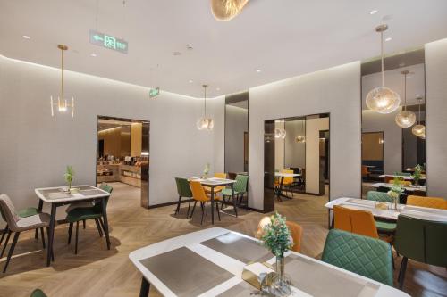 a dining room with tables and chairs and tablesktop at Orange Beijing Yansha Landmark Hotel in Beijing