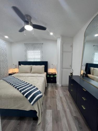 a bedroom with a bed and a ceiling fan at Luxury Tiny Cottage 5 miles from Disney in Kissimmee
