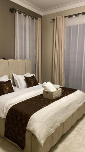 a bedroom with a large bed with white sheets and pillows at Sunshine home by Jae in Kampala