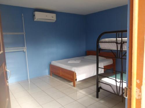 a bedroom with a bunk bed and a blue wall at Cabinas Los Genizaros 