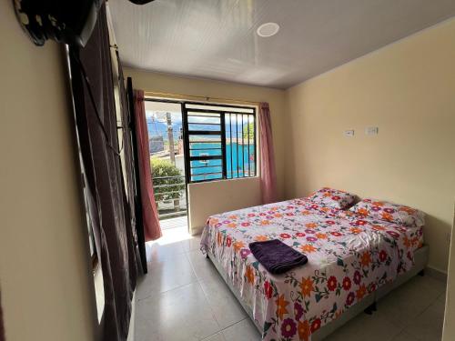 un dormitorio con una cama y una ventana en Casa vacacional de 2 pisos en Restrepo, Meta, en Restrepo