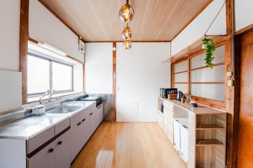 a kitchen with white cabinets and a wooden ceiling at 島原の宿翠泉 in Shimabara