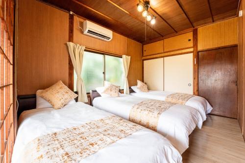 a row of three beds in a room at 島原の宿翠泉 in Shimabara