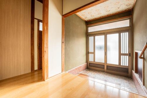 an empty room with a door and a window at 島原の宿翠泉 in Shimabara