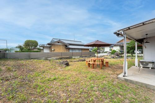 a patio with a table and an umbrella at 島原の宿翠泉 in Shimabara