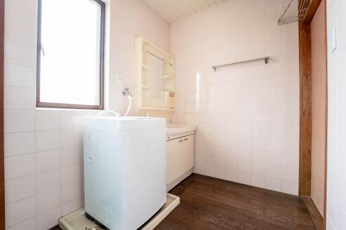 a white bathroom with a sink and a mirror at 島原の宿翠泉 in Shimabara