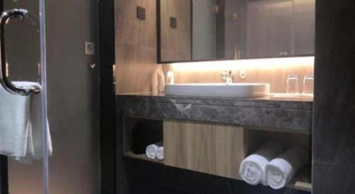 a bathroom with a sink and a mirror and towels at danfeng kelly hotel in Shenzhen