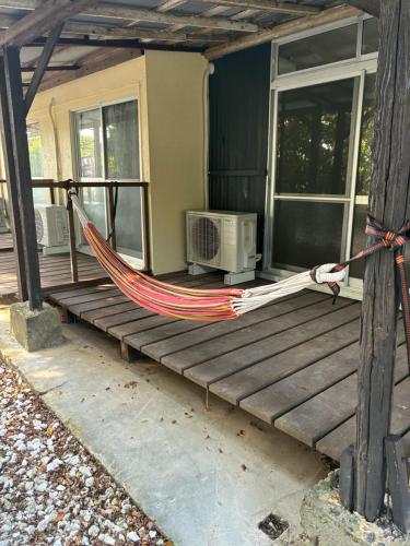 a hammock on the porch of a house at Hostel あざみ庵よろん in Yoron
