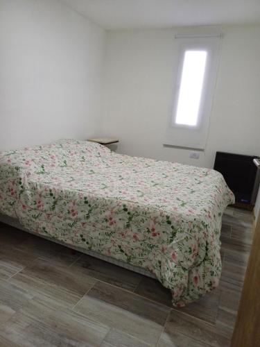 a bedroom with a bed with a floral comforter at El Dorado Stey 2 in Río Grande