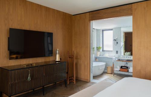 a bedroom with a tub and a tv and a bathroom at Casa Polanco Hotel Boutique in Mexico City
