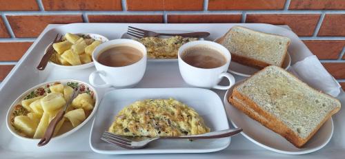 a tray of breakfast food with cups of coffee and toast at Hotel Jay Jay in Āīzawl