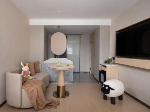 a living room with a couch and a tv at Immersing Hotel Guilin Two Rivers and Four Lakes Dongxi Alley in Guilin