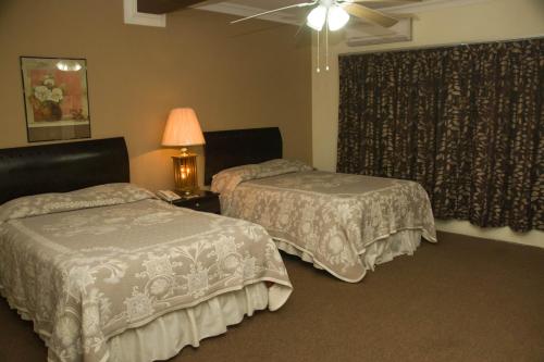 a hotel room with two beds and a window at Hotel Rincon Real Suites in Durango