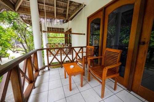 two chairs and a table on a balcony at Fihalhohi Maldives in South Male Atoll