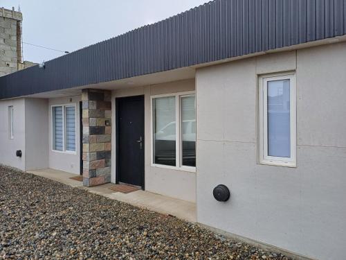 a white house with a black door and windows at El Dorado Stey 2 in Río Grande