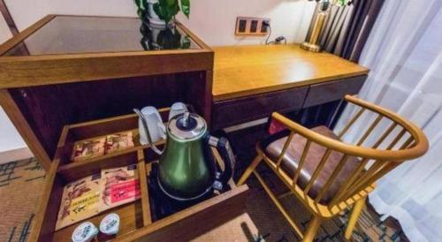 a desk with a tea kettle and a chair in a room at James Joyce Coffetel Changchun People's Square in Changchun