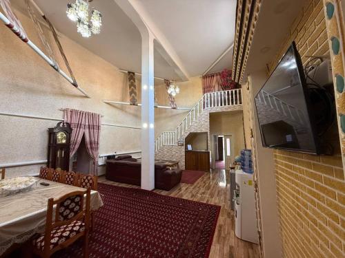 a room with a staircase and a living room at Shodlik Guest House in Khiva