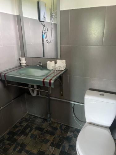 a bathroom with a toilet and a sink at AJ Pizza and Steakhouse in Ban Khai Nun