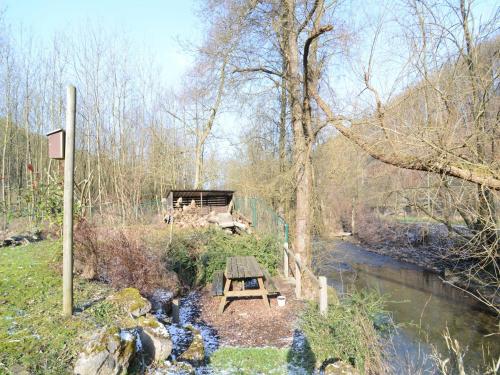 a picnic table sitting next to a river at Cozy Holiday home in Theux in Theux