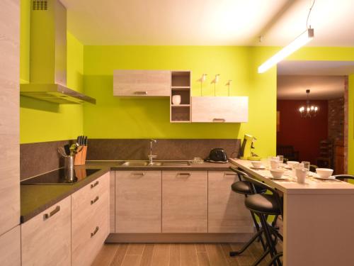 a kitchen with wooden cabinets and green walls at Cozy Holiday home in Theux in Theux