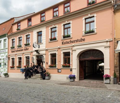 a group of people sitting outside of a building at Hotel Schwarzer Adler Tangermünde in Tangermünde