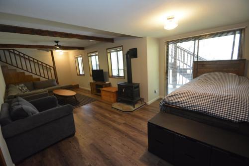 a bedroom with a bed and a couch and a television at SunRidge at Willow Cove in Bass Lake