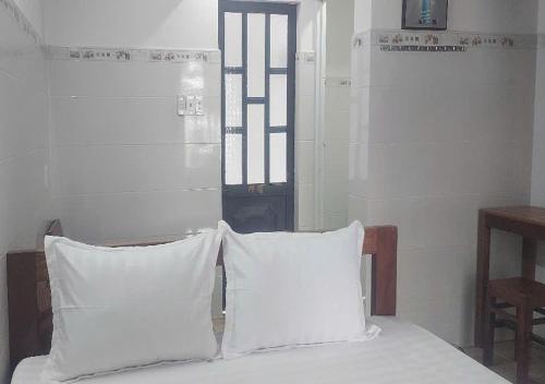 two white pillows sitting on top of a bed at Biển Ngọc Homestay - Ngay sát biển Phan Rang in Bắc Sớn