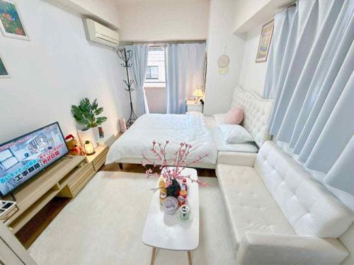 a living room with a white couch and a television at The Isabella Yokohama in Yokohama