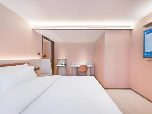 a bedroom with a large white bed and a desk at Hanting Hotel Beijing Fangzhuang Fangxingyuan in Beijing