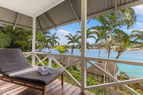 a porch with a bed and a view of the ocean at Iririki Island Resort & Spa in Port Vila