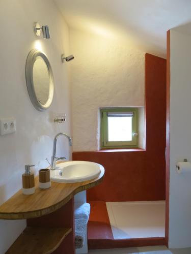 une salle de bain avec un lavabo et un miroir dans l'établissement La Buissonnière, à Oppède