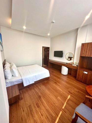 a hotel room with a bed and a television at Hotel ĐÁ ĐỎ in Da Nang