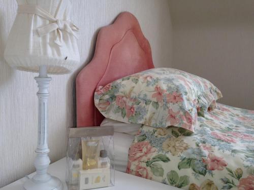 a bedroom with a bed with a pillow and a lamp at Eastwood Cottage in Turriff