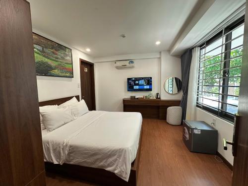 a bedroom with a bed and a television in it at Hotel ĐÁ ĐỎ in Da Nang