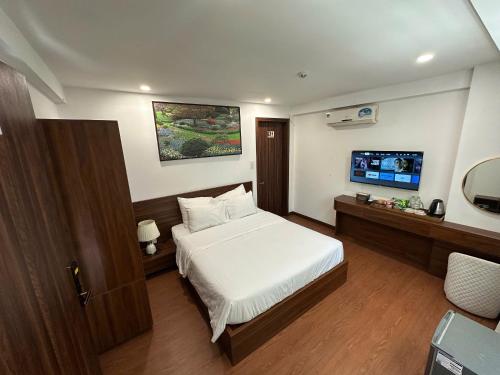 a bedroom with a bed and a flat screen tv at Hotel ĐÁ ĐỎ in Da Nang