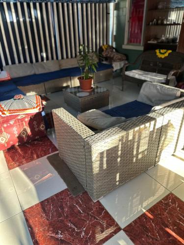 a living room with a wicker couch and a table at SweetBOSS Guesthouse in Ha‘alalo