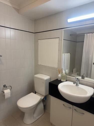 a white bathroom with a toilet and a sink at City CBD Retreat in Perth
