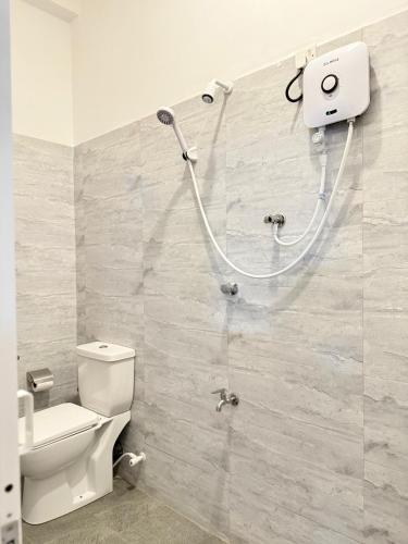 a bathroom with a toilet and a shower in it at Ocean Breeze Cottage in Ahungalla