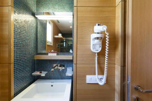 a phone is hanging on a wall in a bathroom at Hotel Novecento in Scicli