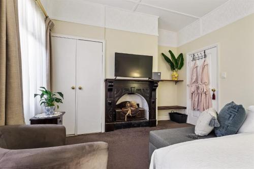 a living room with a fireplace and a tv at Margaret River Guest House in Margaret River Town
