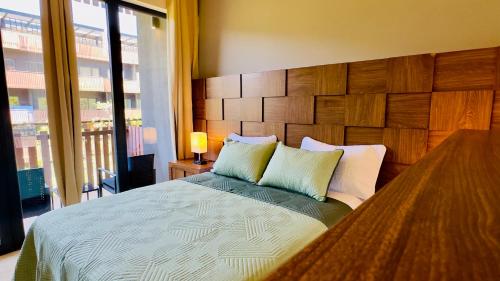 a bedroom with a large bed with a wooden headboard at Jungle Guardian - Rooftop Pool & Beach Club in Zona Hotelera Tulum in Tulum