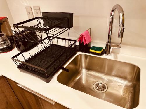 a kitchen sink with a dish drying rack on it at Jungle Guardian - Rooftop Pool & Beach Club in Zona Hotelera Tulum in Tulum